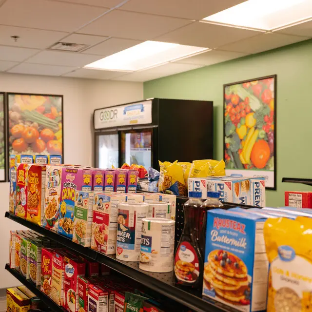 Shelves of cereal, oatmeal, pancake mix, and pantry staples at a partner food shelf.